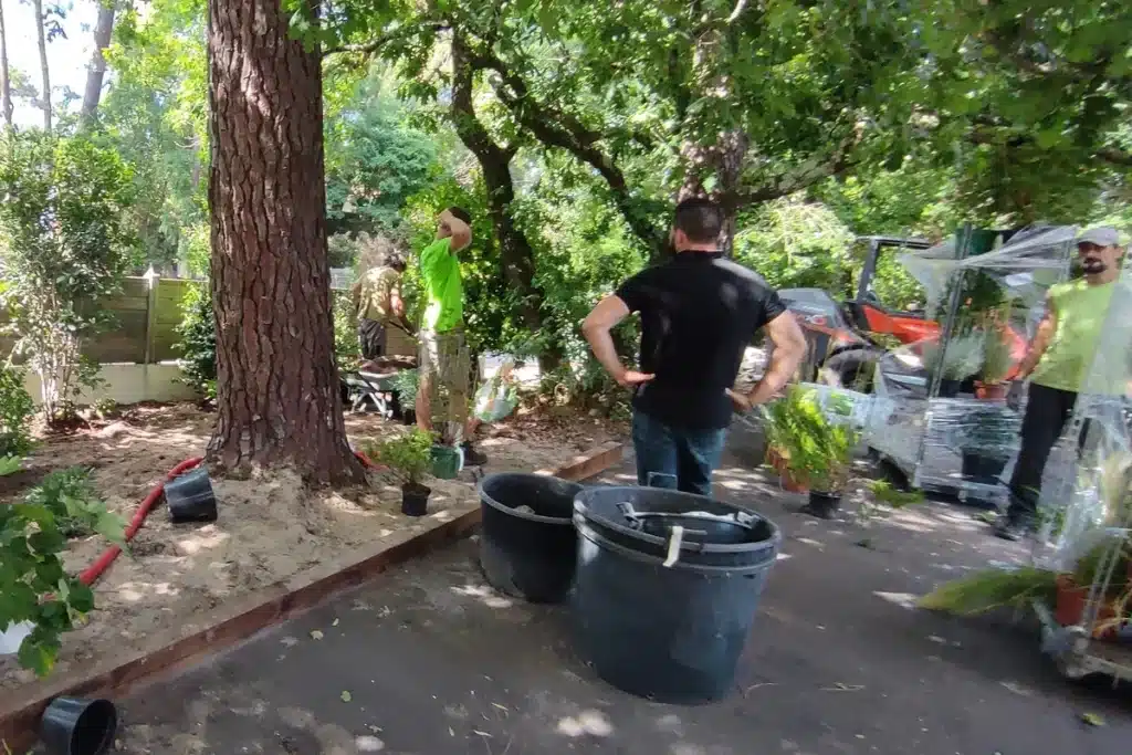 Intervention d’une équipe de paysagistes sur un chantier en pleine nature, supervisant la mise en place des plantations et l’agencement des éléments de jardin pour un aménagement paysager réussi.